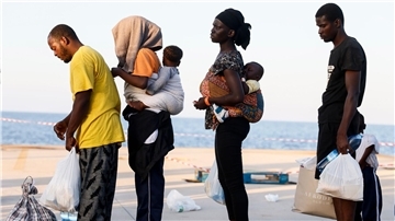 Migranten stehen auf der Insel Lampedusa.