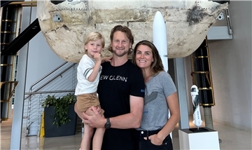 Mike Moore und Familie stehen vor einer Rakete.