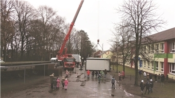 Millimeter-Arbeit vor der Grundschule in Neuenwalde. Ein Kran lässt herunter, was die beengte Klassenraumsituation lindern soll.