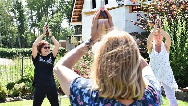 Mit Bieryoga ging es am Samstag los: Linda Icken (links) macht die Übungen mit der Flasche Pils vor.