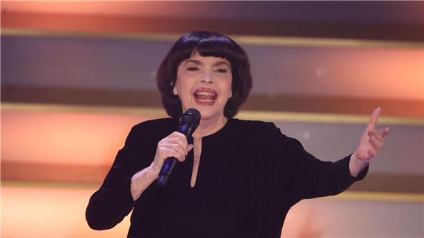 Mit Chanel-Hut und chinesischem Sonnenschirm schützt Chanson-Legende Mireille Mathieu ihre Haut. (Archivbild)