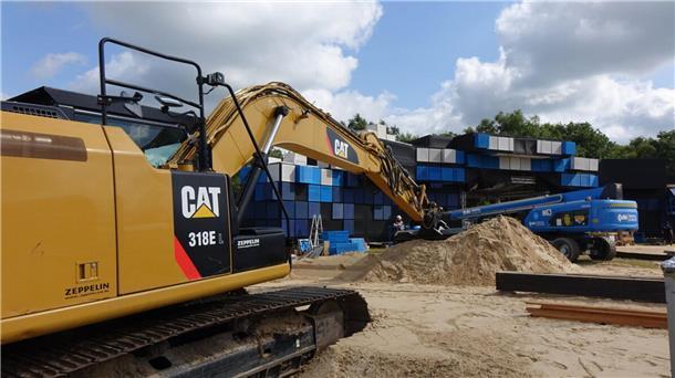 Mit dem Bagger wird der Sand auf dem Gelände (hier vor der Electric-Island-Bühne) verteilt.