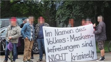 Mit diesem Banner zeigte eine Gruppe von Demonstranten beim ersten Verhandlungstermin ihre Gegnerschaft zur Maskenpflicht.