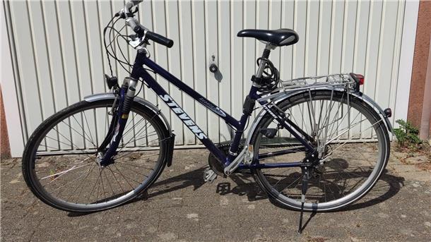 Ein Damenfahrrad (schwarz) steht an einer Wand. Mit diesem Rad als Herrenversion mit Stange ist der Vermisste nach Angaben der Polizei vermutlich unterwegs.