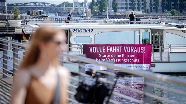Mit einem Plakat an einem Solarschiff wirbt der nationale Nachrichtendienst für Nachwuchs.