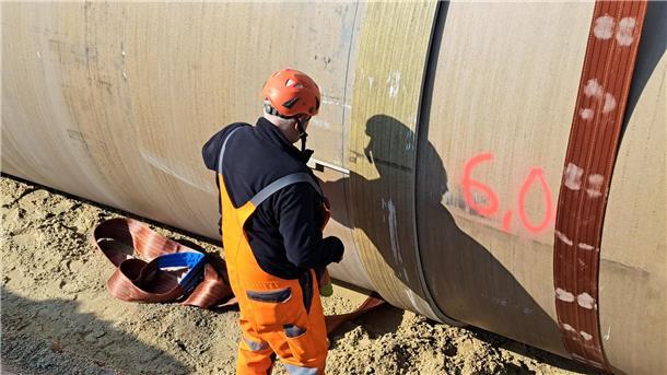 Bilderstrecke von der A27: Das sind die heimlichen Helden der Baustelle Mit einem Zollstock wird nachgemessen und kontrolliert, wie dicht die bis zu acht tonnenschweren Rohrelemente aufeinander geschoben werden. Zudem haben die Bauarbeiter die Länge der Rohe ausgemessen und mit roter Farbe aufgeschrieben, da sie unterschiedlich lang sind.