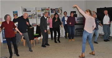 Mit einer Disco-Choreografie lässt Chaline Baschin (von hinten) die Besucher des Tanztees im MGH übers Parkett wirbeln.