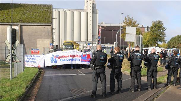 Mit einer Sitzblockade protestieren Aktivisten vor der Zufahrt eines Hafendienstleisters in Bremen-Walle. 