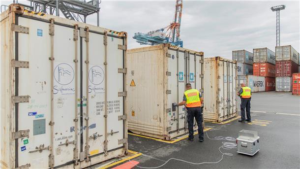 Zwei Zollbeamte arbeiten an Containern am Containerterminal in Bremerhaven.