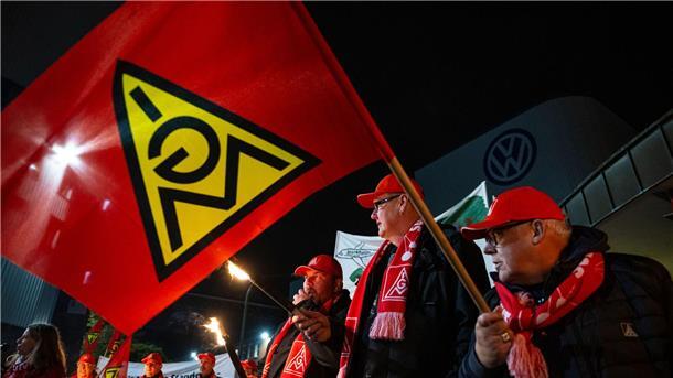 Warnstreiks an zahlreichen Werkstoren in Niedersachsen Mit Gewerkschafts-Fahnen stehen Mitarbeiter vor dem Volkswagen-Werk.