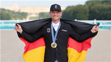 Mit Gold und deutscher Fahne in Versailles