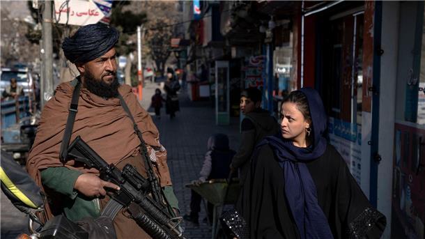 Afghanistan: Frauen bleiben von Bildung ausgeschlossen Mit kritischem Blick geht eine Frau in Kabul an einem Taliban-Kämpfer vorbei. Die Islamisten machen bisher keine Anstalten, älteren Mädchen und Frauen den Zugang zu Bildungseinrichtungen zu gewähren.