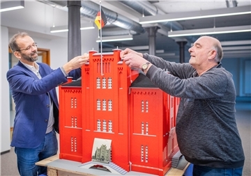 Maurer Uwe Naumann von der Fischereihafen Betriebsgesellschaft (FBG) baute mit knapp 100.000 Legosteinen das historische Gebäude der Nordsee am Handelshafen nach. Maßstab: 1:23. Das Modell wurde zur Einweihung des Gebäudes fürs Alfred-Wegener-Institut dort aufgestellt.  FBG-Prokurist Sebastian Gregorius (links) und Uwe Naumann ruckeln noch mal dran - alles einsturzsicher. 
