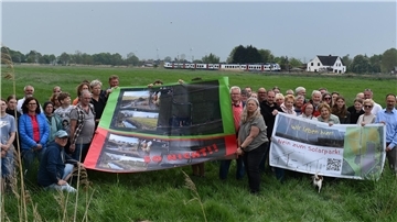 Eine Gruppe von Menschen mit Protestbannern. Anwohner in Sürwürden/Alse in der Gemeinde Stadland wehren sich gegen einen dort geplanten Solarpark