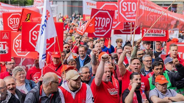 Mitarbeitende stehen bei einer Demonstration vor der Konzernzentrale von Thyssenkrupp.