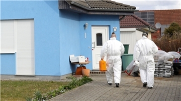 Mitarbeiter der Kriminaltechnik gehen in das Haus in Rövershagen, in dem drei Menschen getötet wurden (Archivbild).