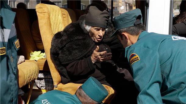 Mitarbeiter des armenischen Ministeriums für Notfallsituationen sprechen mit einer älteren armenischen Frau aus Berg-Karabach bei ihrer Ankunf in Goris.