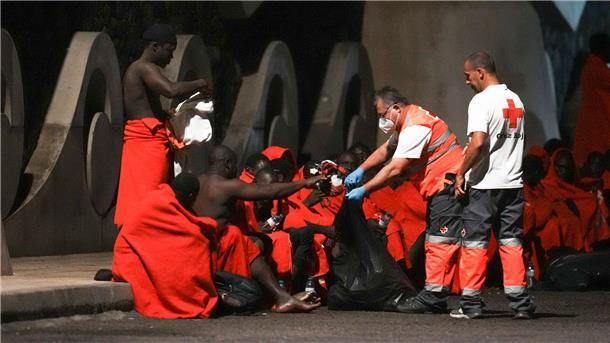 Erneut Migranten bei Überfahrt ums Leben gekommen Mitarbeiter des Roten Kreuzes verteilen im November Wasser an Migranten an einer Anlegestelle im Hafen von La Restinga auf der kanarischen Insel El Hierro.