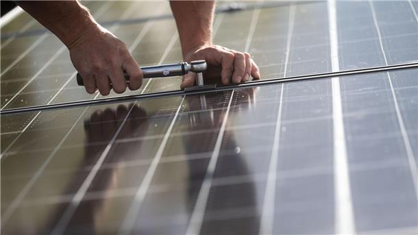 Energiewende treibt Preise für Edelmetalle nach oben Mitarbeiter einer Firma montieren Photovoltaikmodule auf dem Dach eines Wohnhauses.