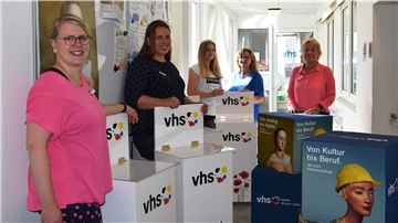Mitarbeiterinnen der Volkshochschule stellen das neue Programm vor.