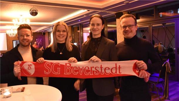 Vier Menschen mit Vereinsschal