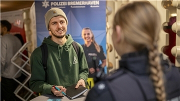 Moritz Camin im Gespräch mit einer Mitarbeiterin der Bremerhavener Polizei. Wer eine Ausbildung bei der Polizei machen will, sollte zupacken können.