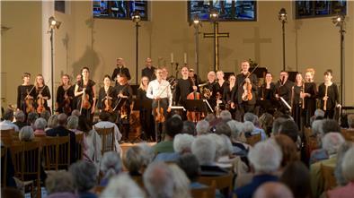Chor, Dirigent und viele ältere Zuhörer beim Konzert in der Kirche. 