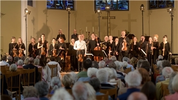 Chor, Dirigent und viele ältere Zuhörer beim Konzert in der Kirche. 