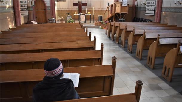 Eine Kirchenbesucherin in St. Jakobi hat sich in eine Wolldecke gehüllt