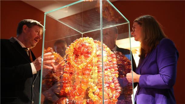 Ribnitz-Damgarten erwirbt Bernstein-Kunstsammlung Museumsleiter Axel Attula (l-r) und Kulturministerin Bettina Martin betrachten das Exponat „Wasserfall“ oder „Goldener Kettenberg“.