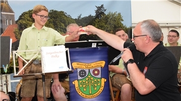 Musikzug-Vorsitzender Thiemo Postels überreicht „Buschfest-Baby“ Max von den Werrataler Musikanten an dessen 12. Geburtstag Geschenke.