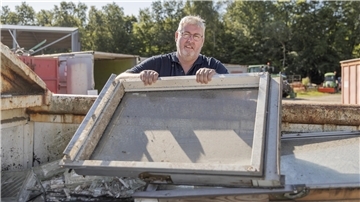 Ein Mann hält ein Fenster mit Rahmen
