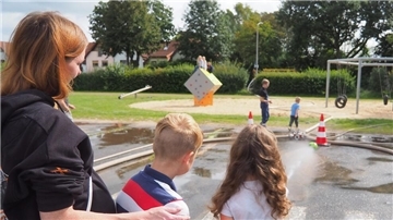 Mutter Bianca hält Sohn Lionel (10), der zusammen mit seiner Schwester Ajvi (9) den Ball mit einem Wasserstrahl ins Tor lenkt.