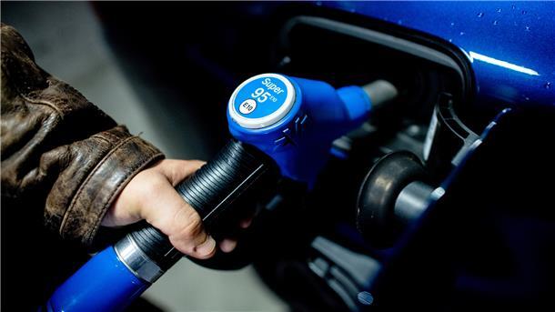 Ein Mann steckt kurz nach Mitternacht die Zapfpistole aus der Tanksäule an einer Tankstelle in sein Fahrzeug, um es mit Super E10 zum Preis von 1,799 Euro je Liter zu betanken.