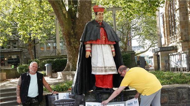 Bistum lässt Hengsbach-Skulptur entfernen Nach Missbrauchsvorwürfen gegen den 1991 gestorbenen Essener Kardinal Hengsbach stellen die Betroffenenvertreter Markus Elstner (l) und Wilfried Fesselmann Protesttafeln auf.