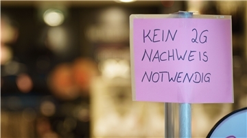 Ein Schild mit der Aufschrift "Kein 2G-Nachweis notwendig" steht am Eingang zu einem Geschäft in der Darmstädter Innenstadt.