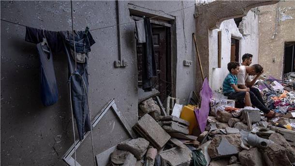 Nachdem es von einem israelischen Luftangriff getroffen wurde, sitzen Palästinenser auf den Trümmern eines Hauses Chan Junis.