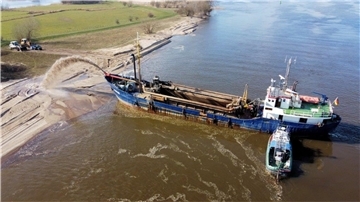 Per Schiff wird Sand an den Strand gespült.