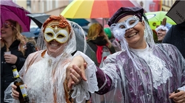 Narren auf dem Marktplatz in Wittlich an  Weiberfastnacht. Auch am Rosenmontag kann es nass werden.