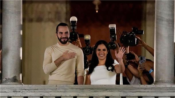 Umstrittener Präsident El Salvadors bei Wahl vorne Nayib Bukele und seine Frau Gabriela Rodriguez lassen sich auf dem Balkon des Präsidentenpalastes feiern.