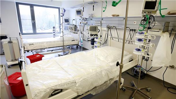 Neben leeren Intensivbetten stehen Beatmungsgeräte.