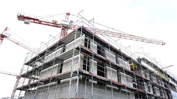Ein Arbeiter auf einer Baustelle für Wohnungen auf der auch staatlich geförderte Wohnungen entstehen. 