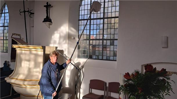Küsterin Irmgard Koppenhagen putzt die großen Fenster der St. Marienkirche in Wersabe.