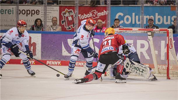 Eine Torraumszene im Eishockey. Nico Krämmer von den Fischtown Pinguins aus Bremerhaven verpasst nur knapp den Puck vor dem gegnerischen Gehäuse.