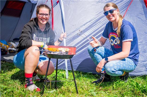 Nina und Maren (rechts) grillen vor ihrem Zelt.