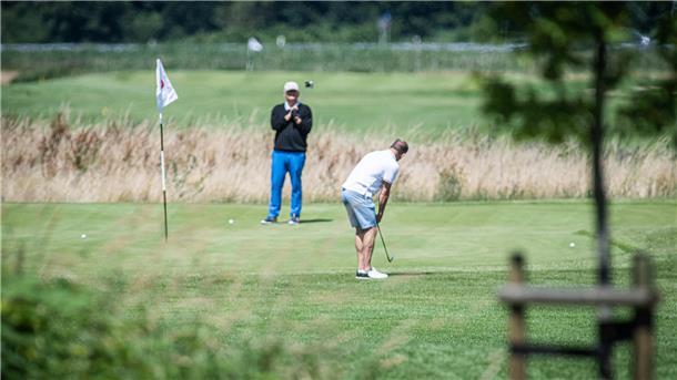 Zwei Männern spielen Golf.