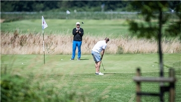 Zwei Männern spielen Golf.