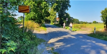 Zwei Radfahrer auf einer Straße.