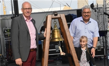 Ein Kind schlägt eine Glocke.