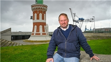 Seemannspastor Andreas Latz sitzt auf einem Stein.